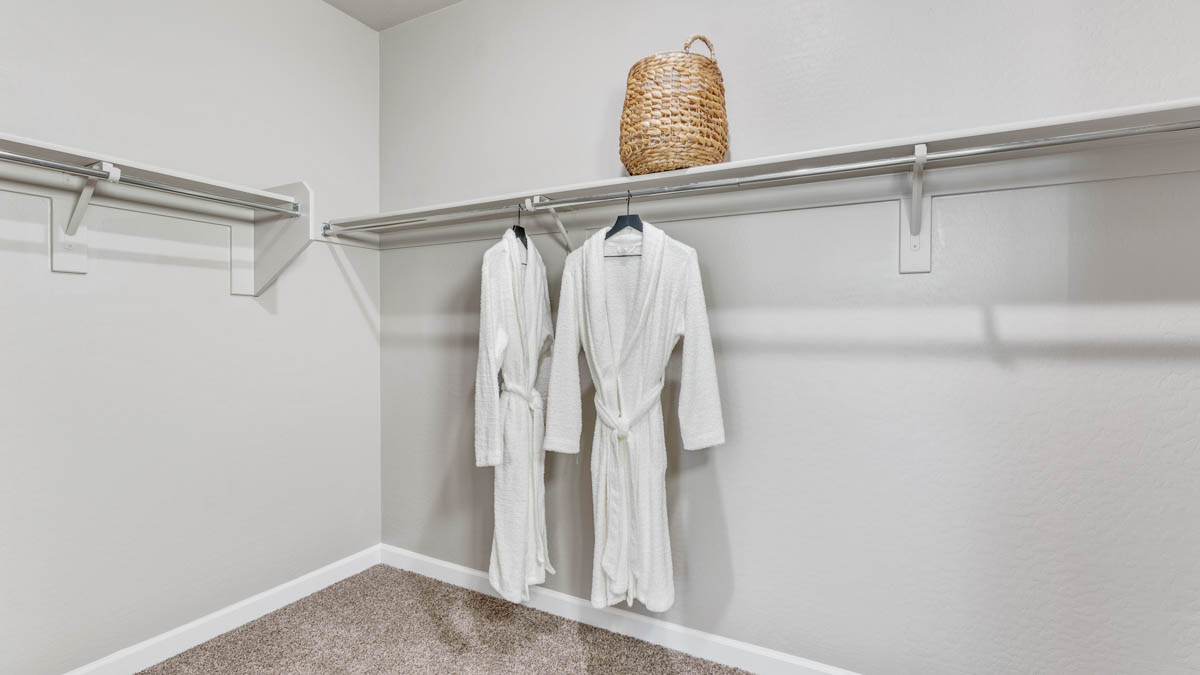 Modern primary bathroom with double vanities, quartz countertops with a walk-in shower and a walk-in closet.