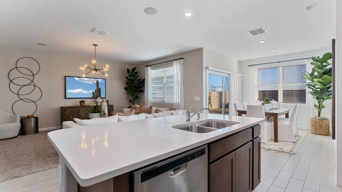 Bright and spacious kitchen with quartz countertops, stainless steel appliances, and an island with bar seating.