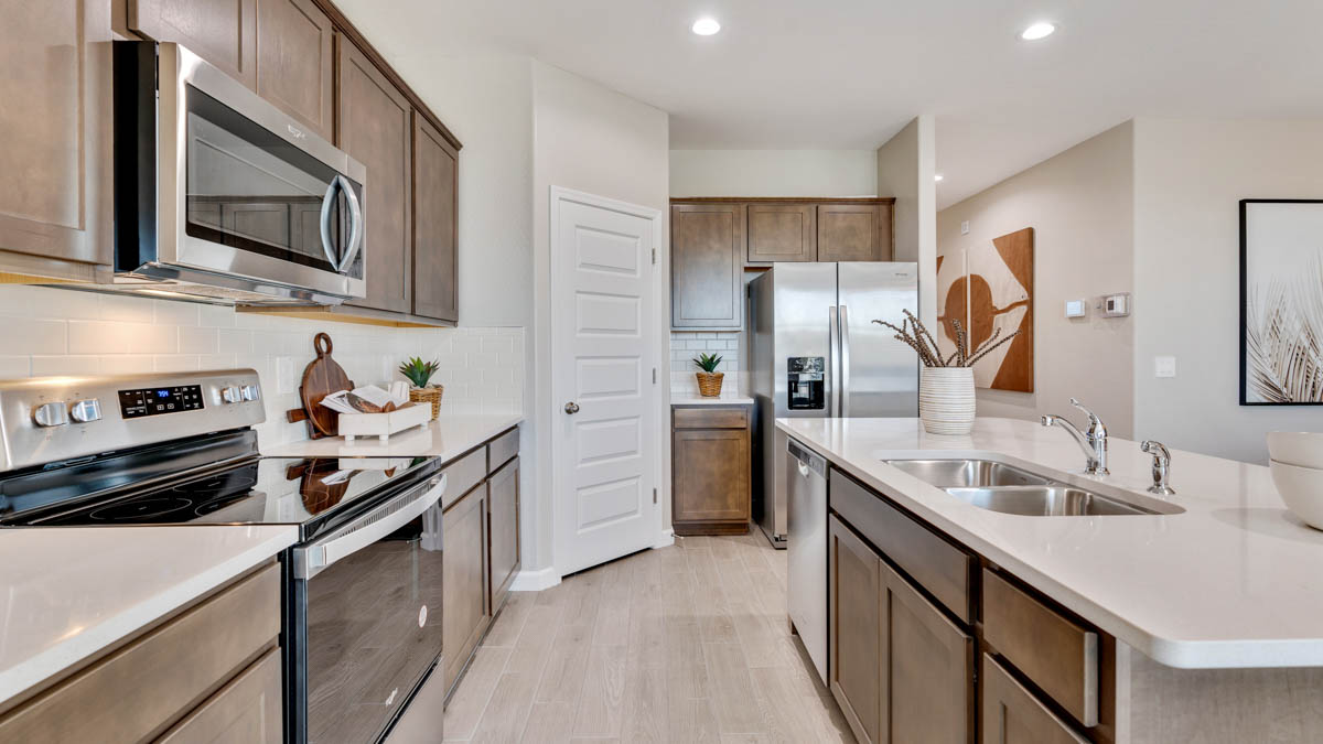 Bright and spacious kitchen with quartz countertops, stainless steel appliances, and an island with bar seating.