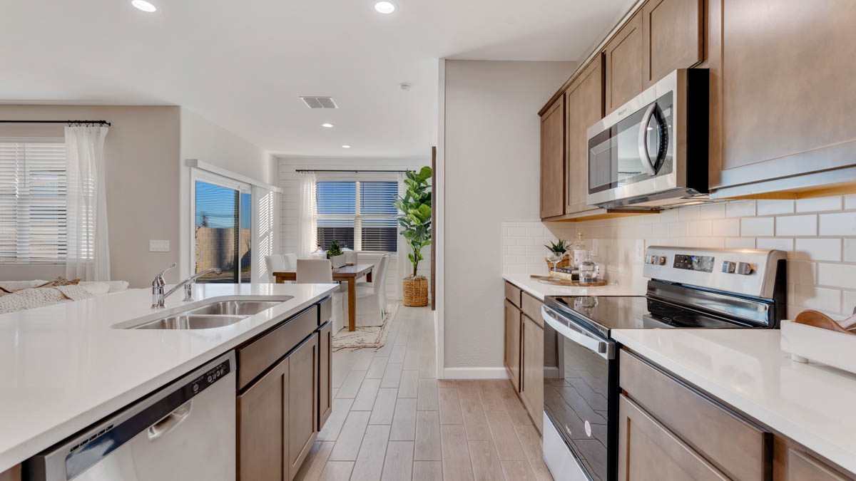 Bright and spacious kitchen with quartz countertops, stainless steel appliances, and an island with bar seating.