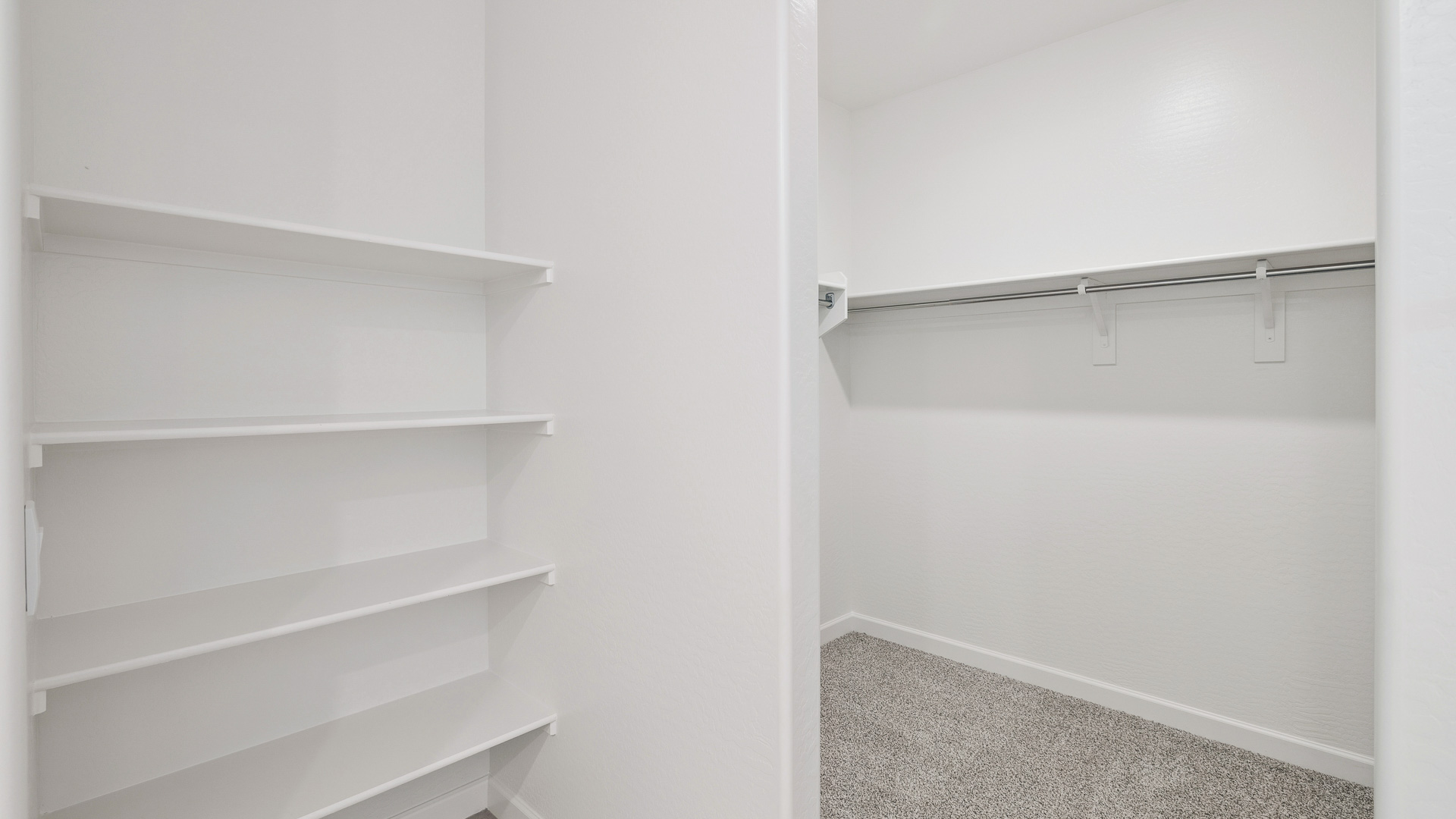 Modern primary bathroom with double vanities, quartz countertops with a walk-in shower and a walk-in closet.