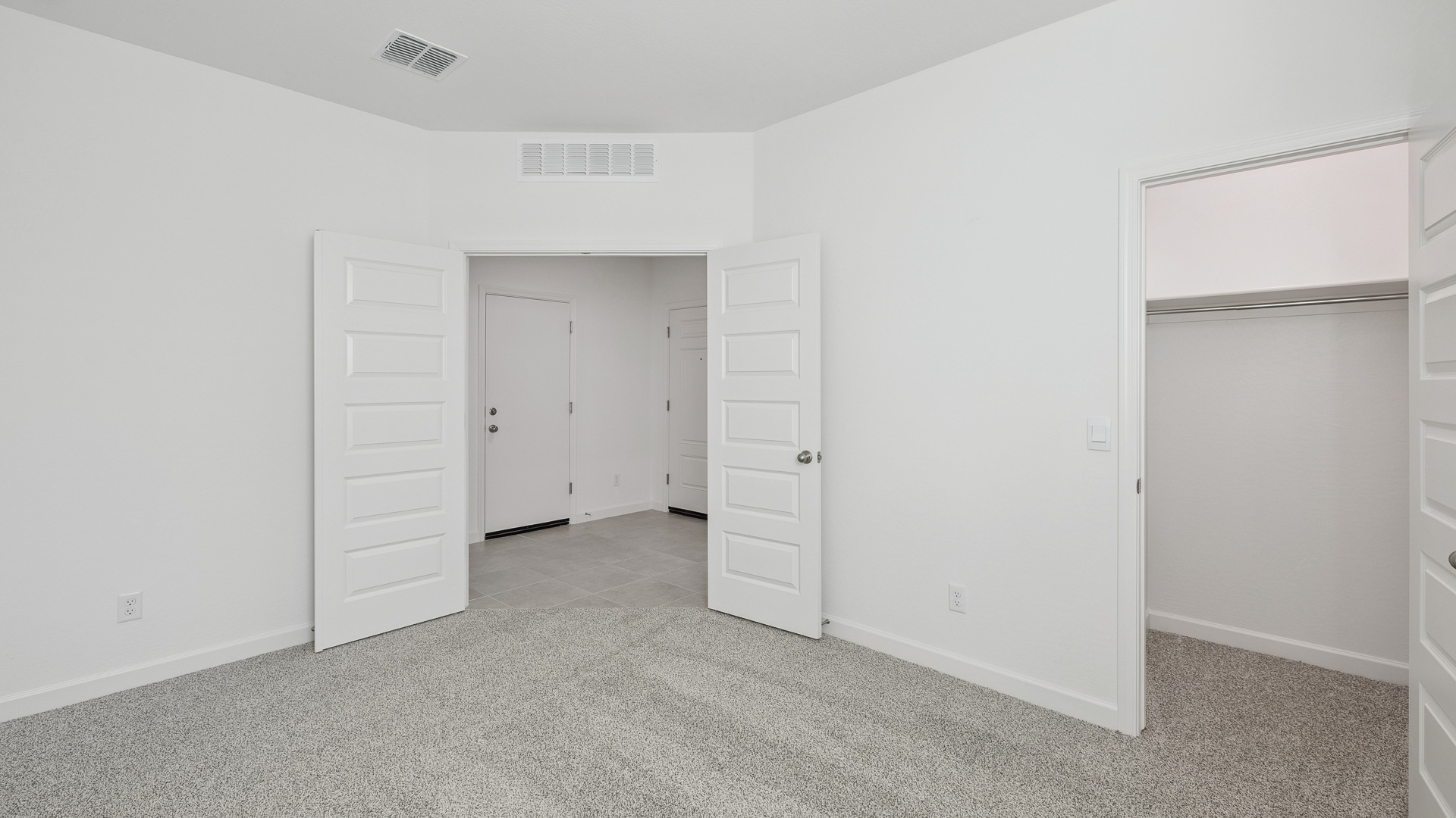 Comfortable guest bedroom featuring neutral-toned walls and a large closet.