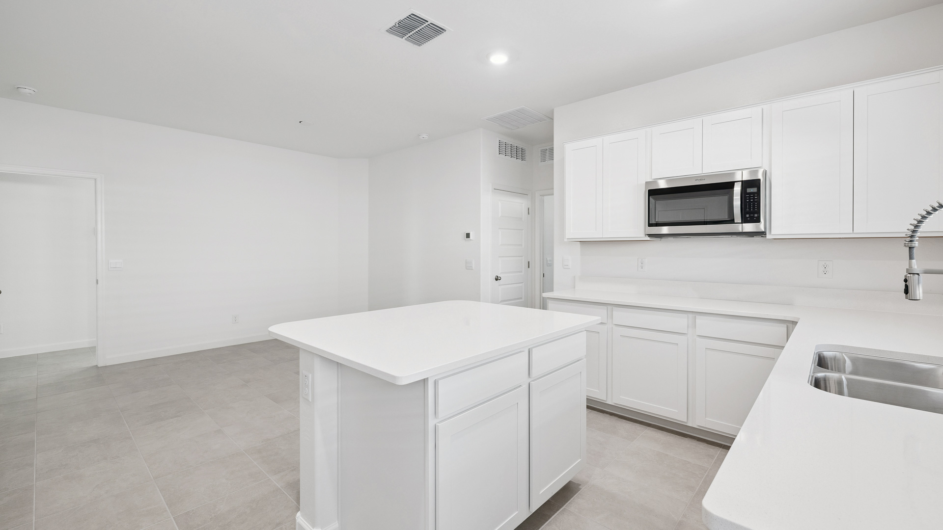 A well-organized living room that includes a kitchen and dining area, creating a warm and welcoming environment for gatherings.