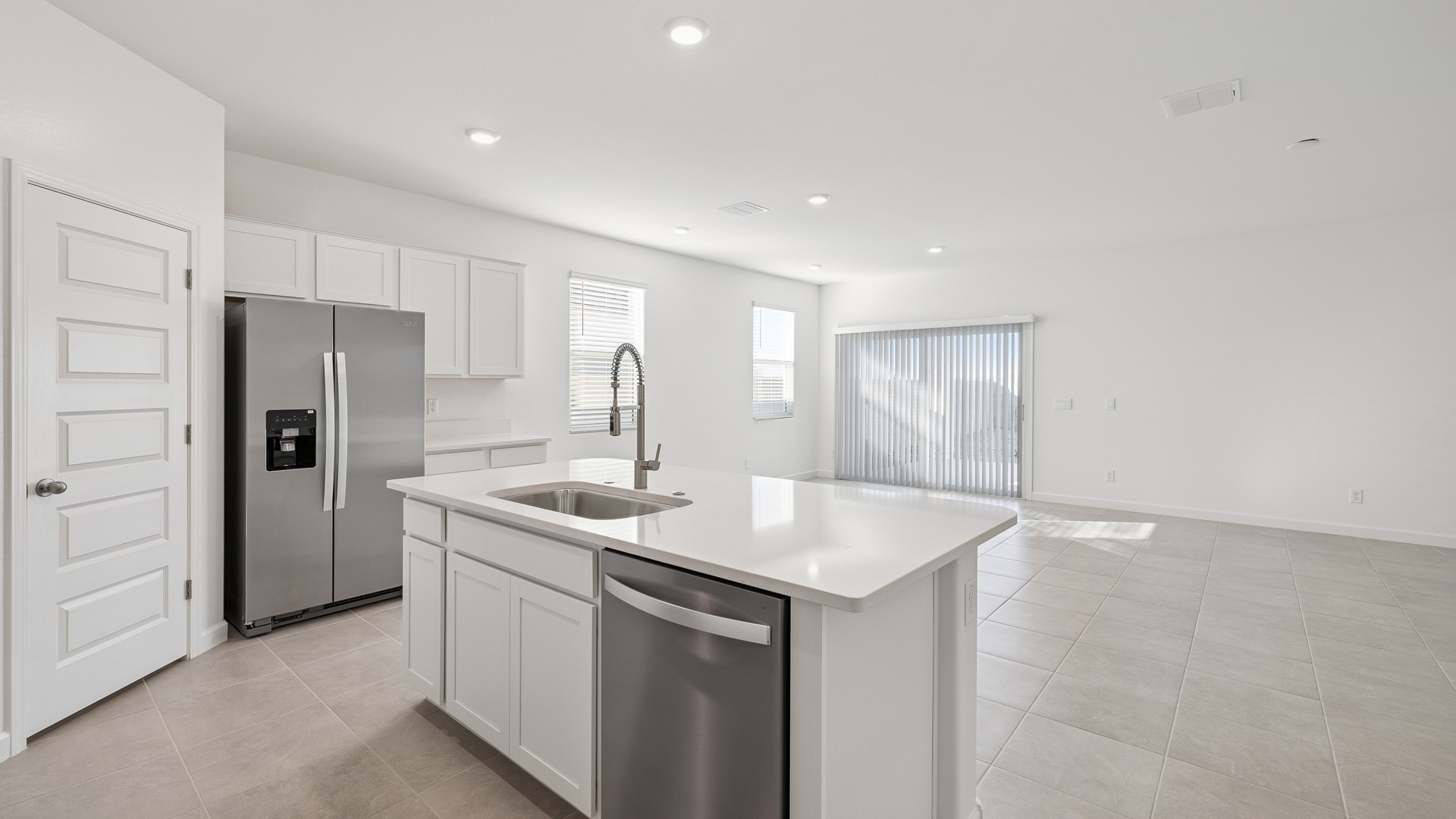 Bright and spacious kitchen with quartz countertops, stainless steel appliances, and an island with bar seating.