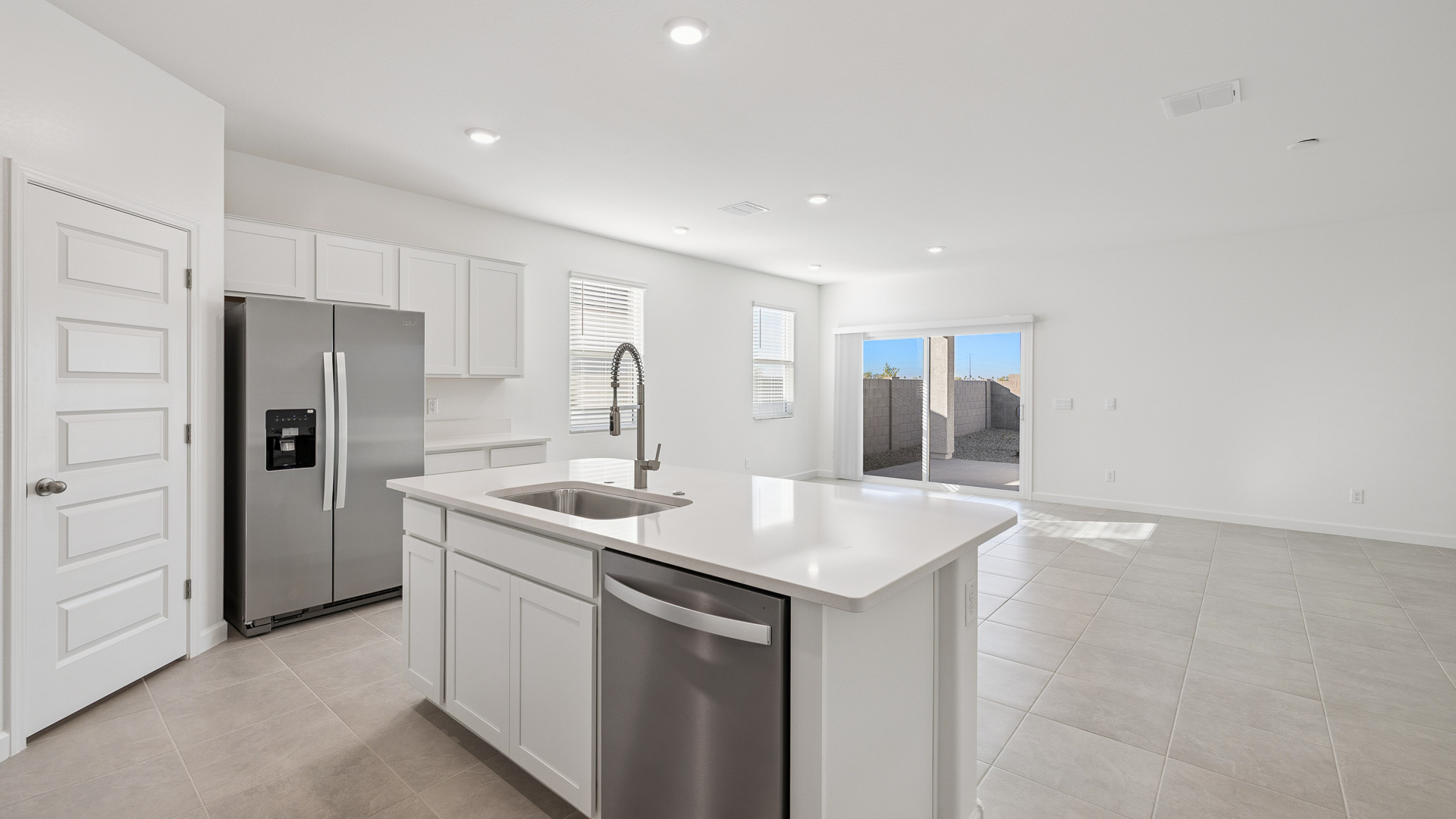 Bright and spacious kitchen with quartz countertops, stainless steel appliances, and an island with bar seating.