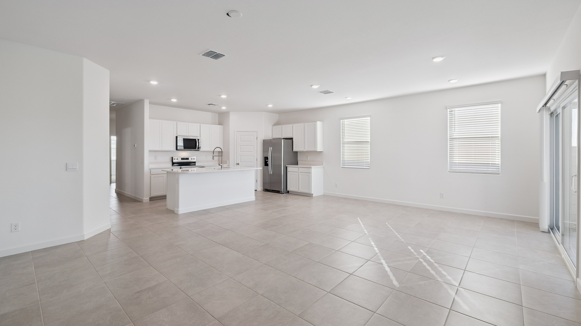 A well-organized living room that includes a kitchen and dining area, creating a warm and welcoming environment for gatherings.