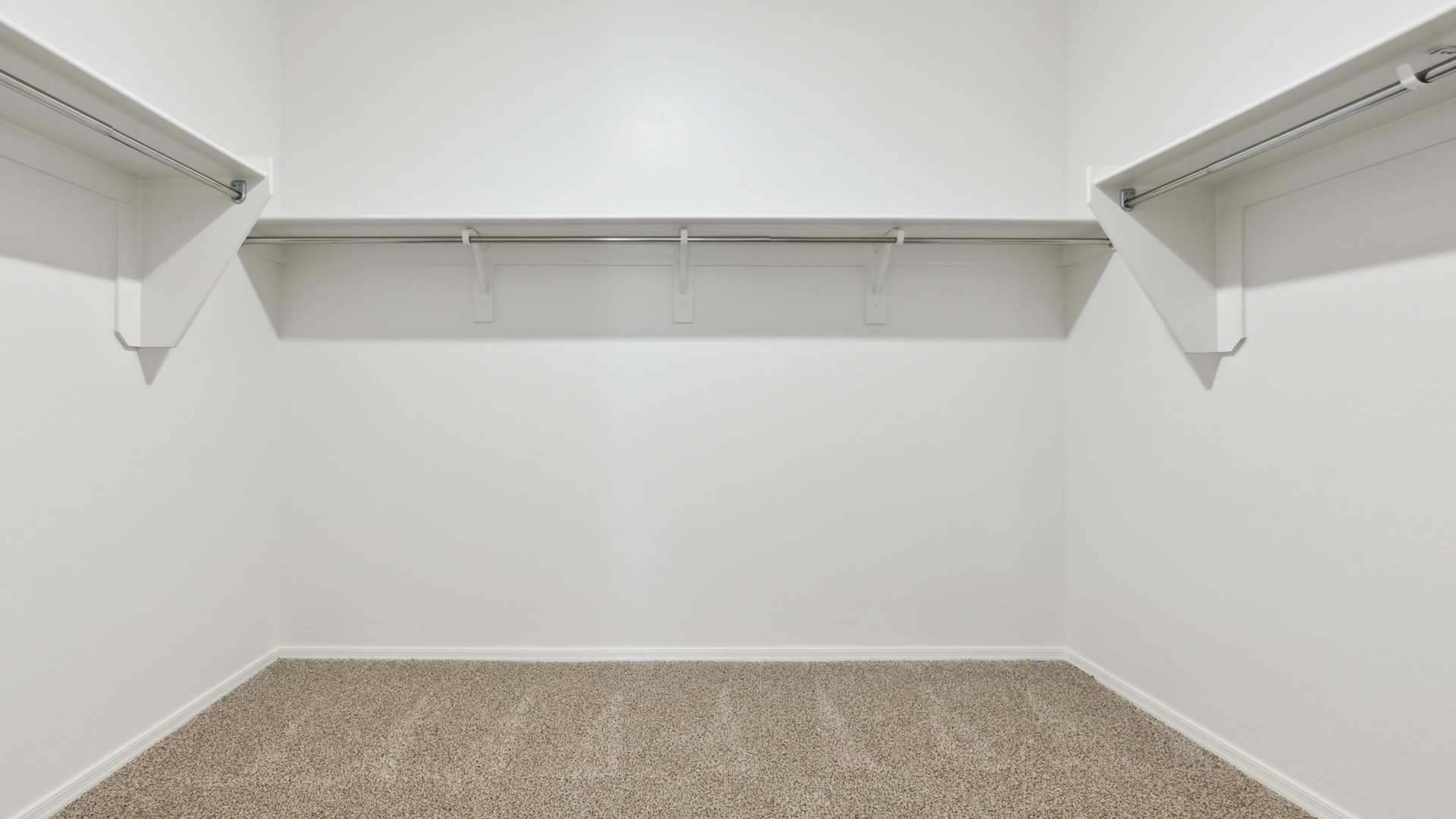 Modern primary bathroom with double vanities, quartz countertops with a walk-in shower and a walk-in closet.