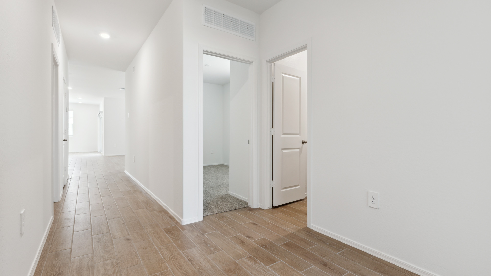 Walkway into the kitchen, living, and dining room with hardwood floors.