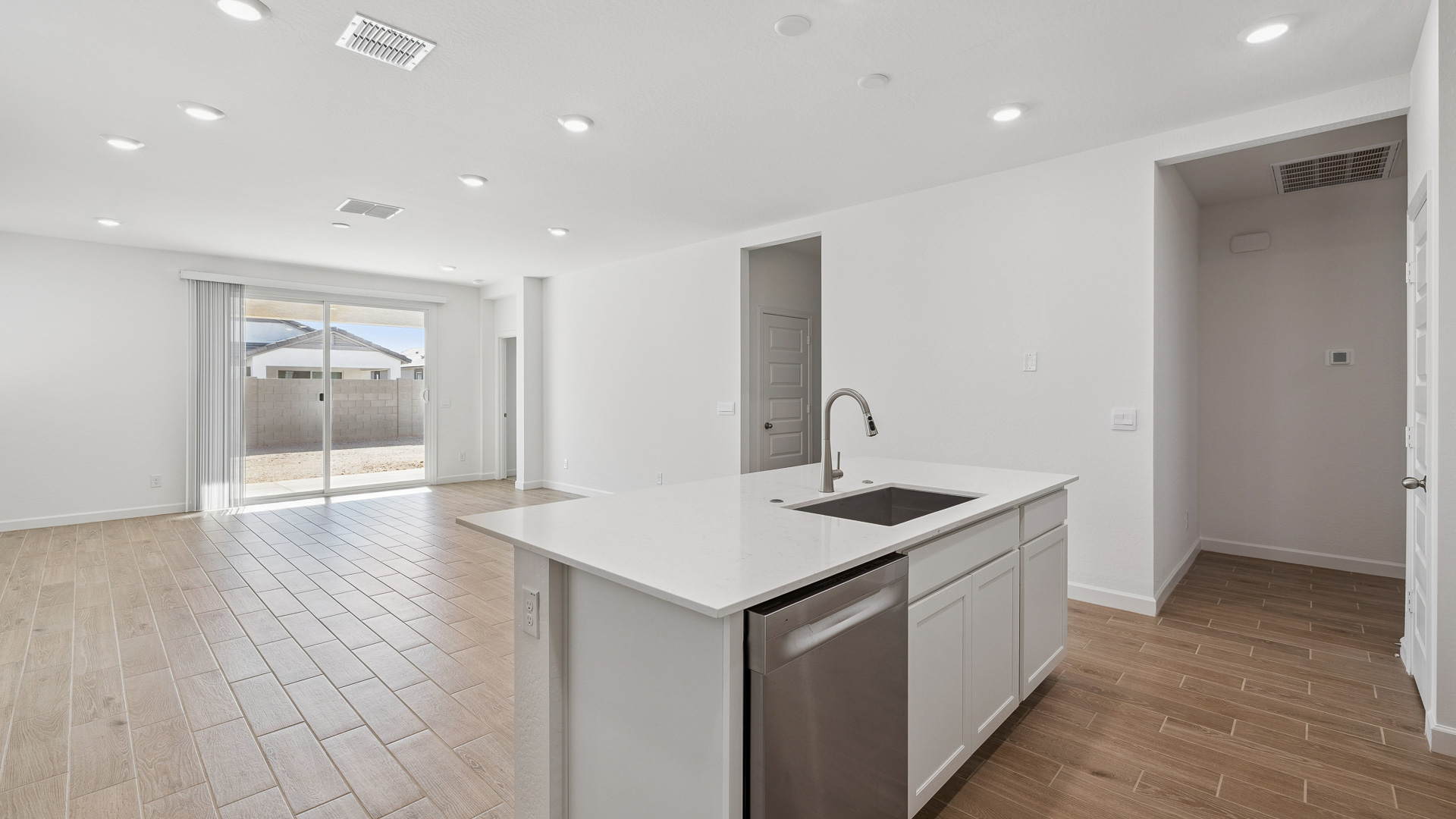 Bright and spacious kitchen with countertops, stainless steel appliances, and an island with bar seating.