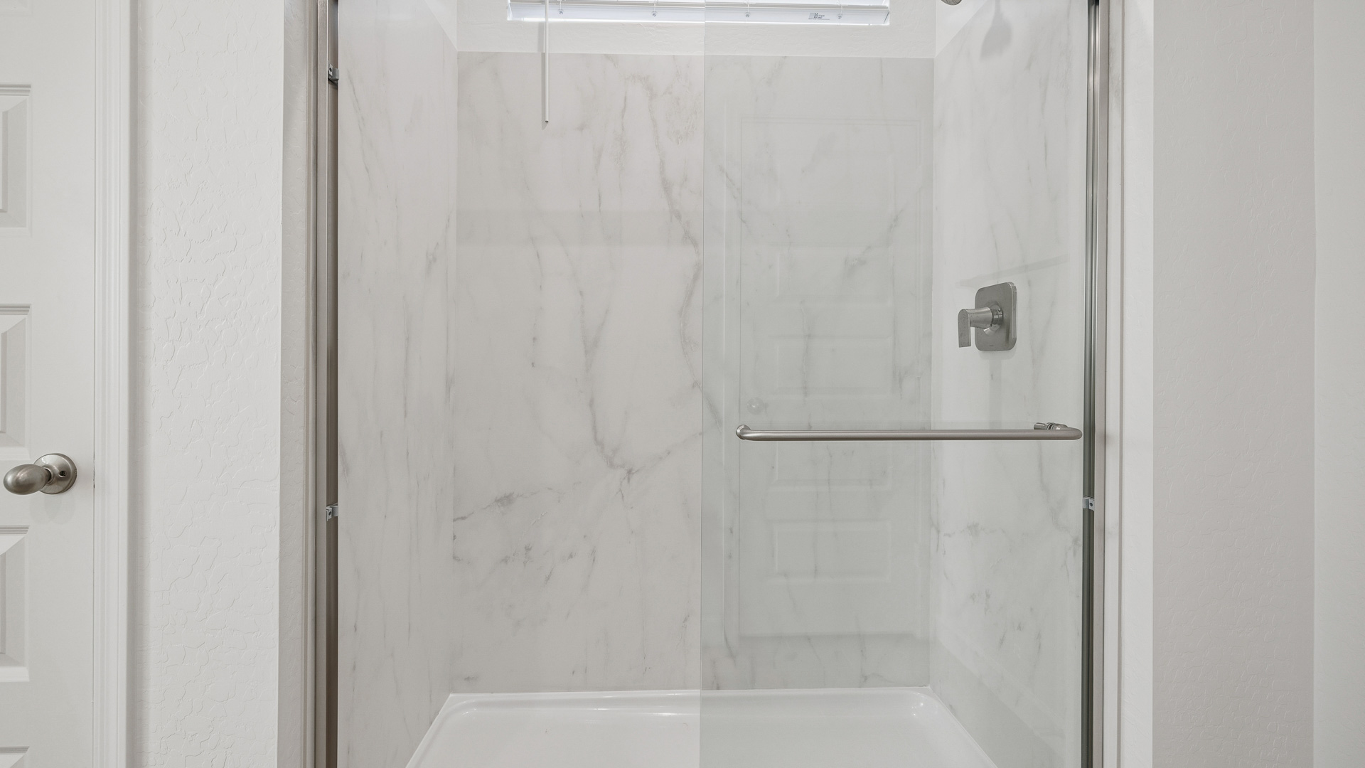 Modern primary bathroom with double vanities, countertops with a walk-in shower and a walk-in closet.