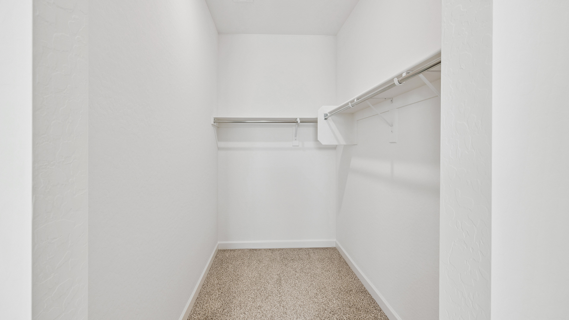 Modern primary bathroom with double vanities, quartz countertops with a walk-in shower and a walk-in closet.