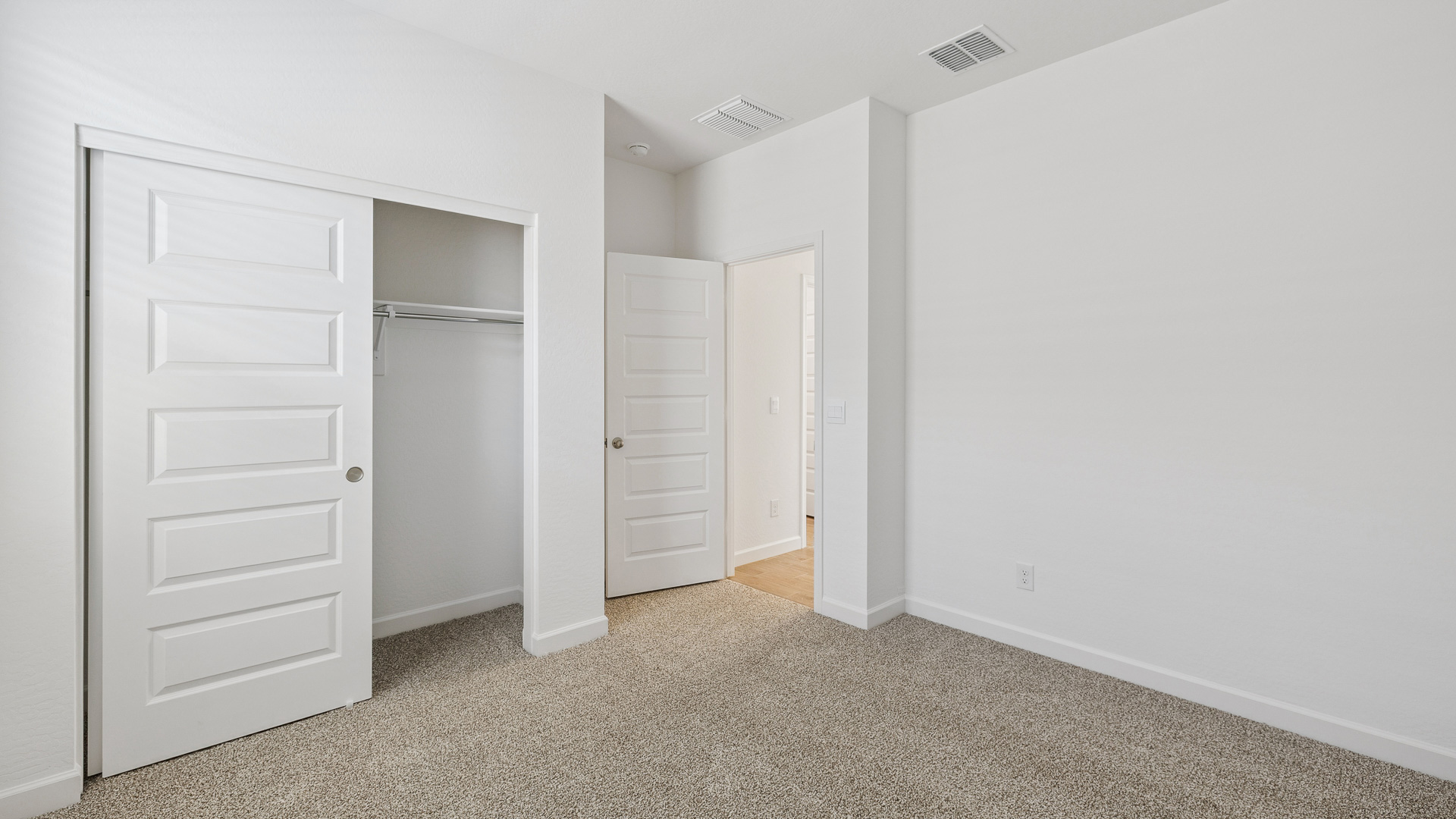 Comfortable guest bedroom featuring neutral-toned walls and a large closet.