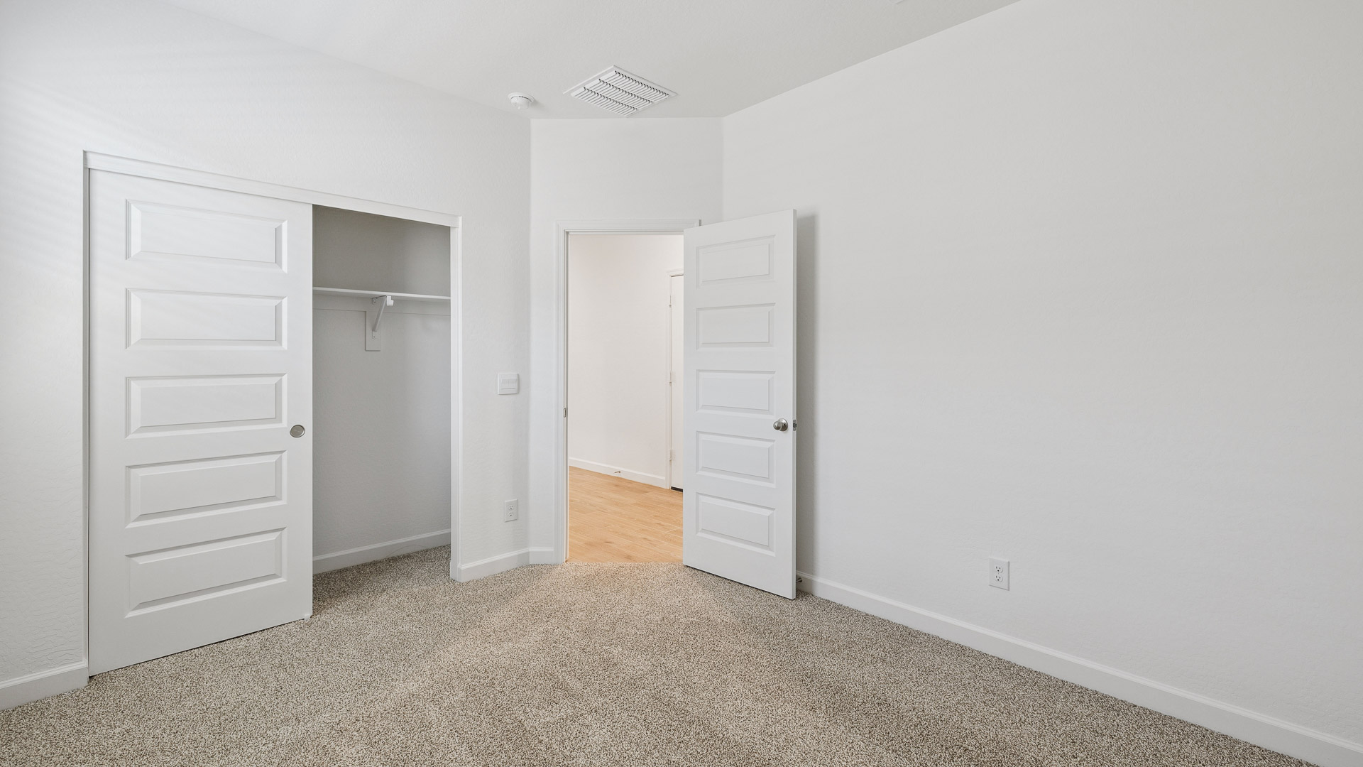 Comfortable guest bedroom featuring neutral-toned walls and a large closet.
