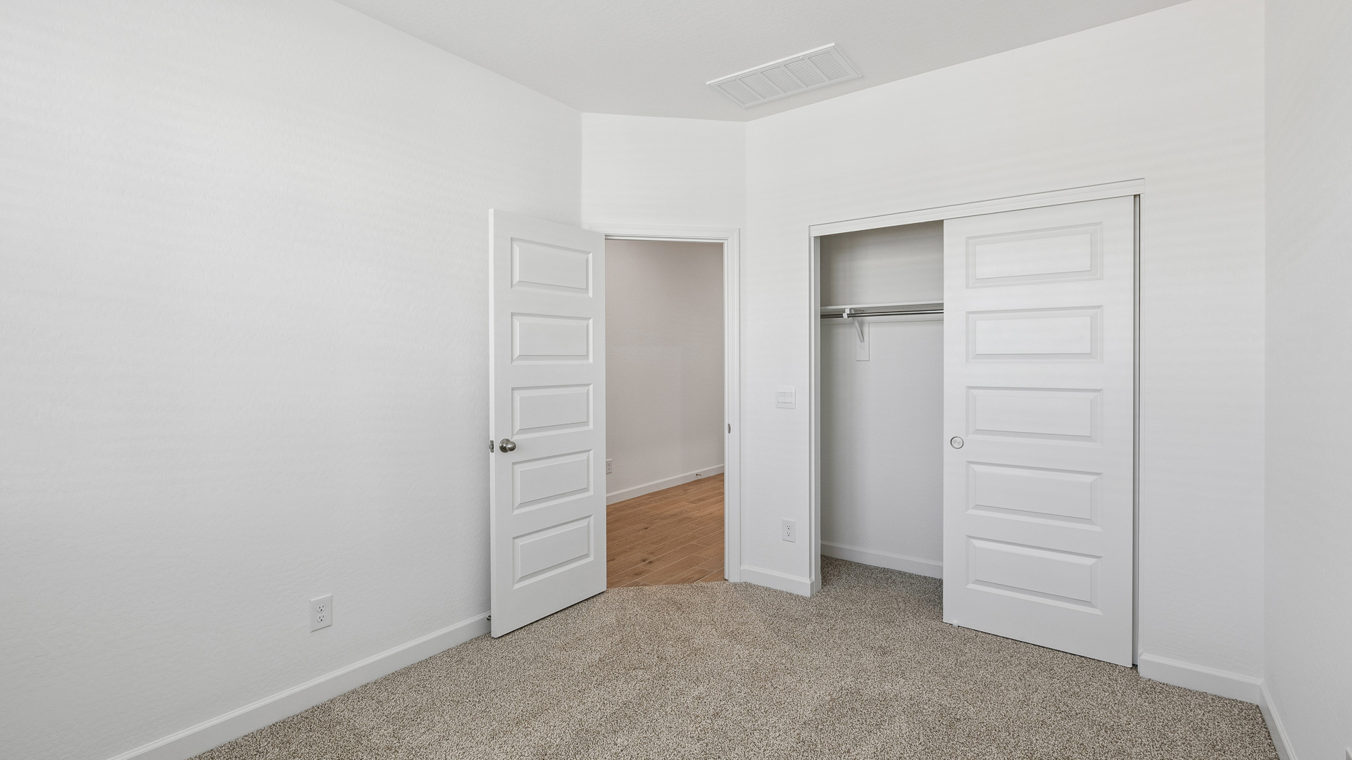 Comfortable guest bedroom featuring neutral-toned walls and a large closet.