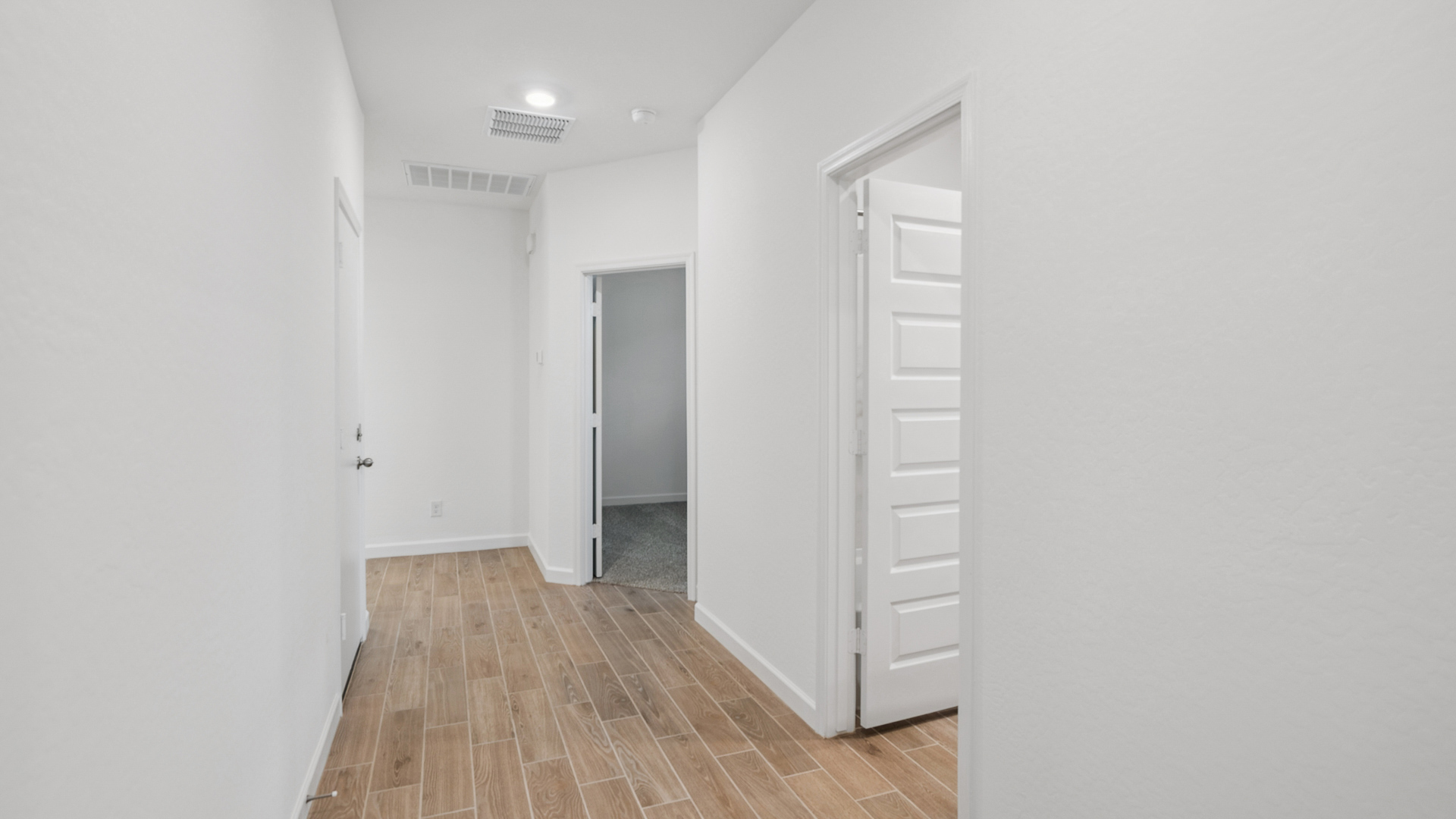 Entry hallway leading to living room and kitchen in the background.