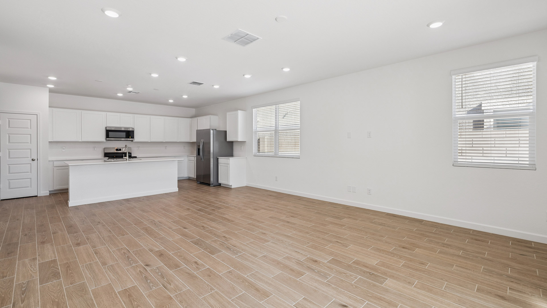 A well-organized living room that includes a kitchen and dining area, creating a warm and welcoming environment for gatherings.