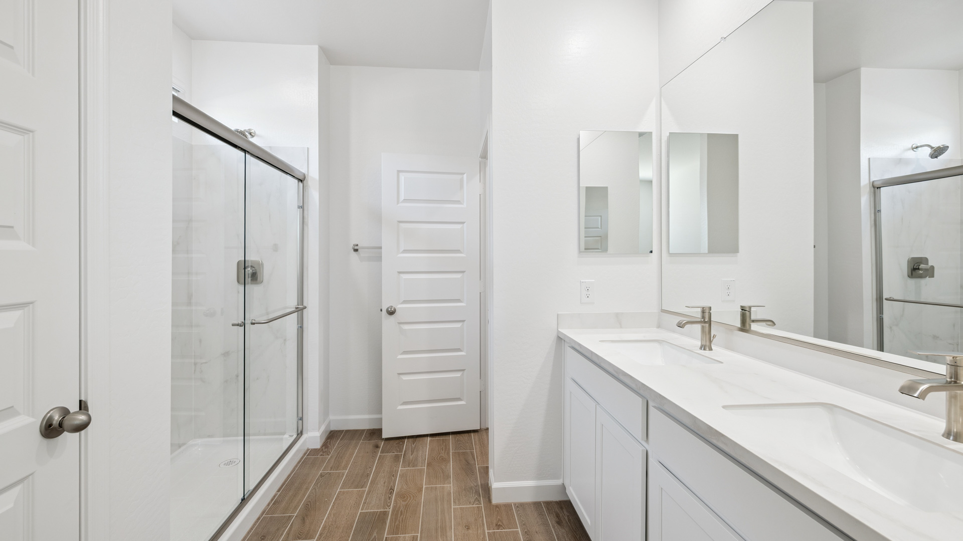 Primary bathroom with dual vanities.