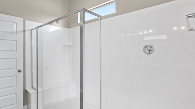 Primary bathroom with dual vanities and a walk-in shower.