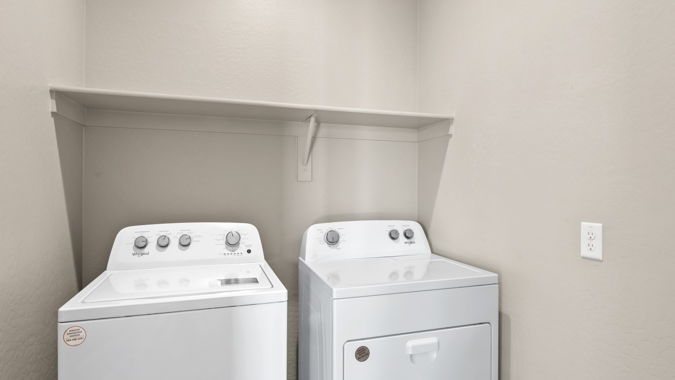 Spacious laundry room with shelving.
