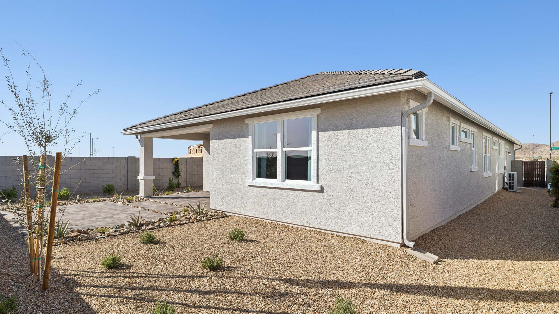 Outdoor covered patio with seating area overlooking a well-maintained lawn, perfect for relaxation.