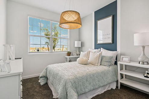 Bedroom with a bed, two nightstands, and a large window.