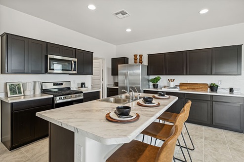 Kitchen featuring brown cabinets, stainless steel appliances, and a large island.