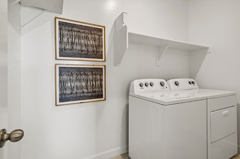 Laundry room with shelf above appliances.