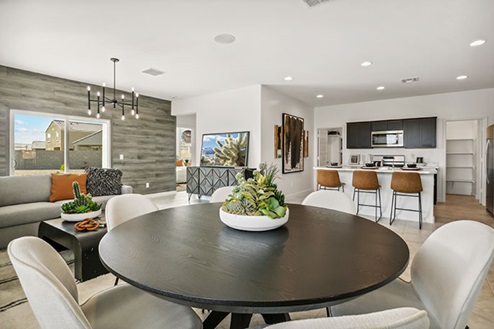Dining area with large round table and chairs.