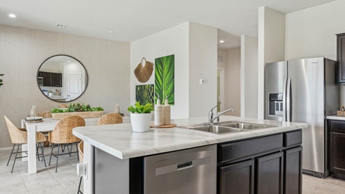 Bright and spacious kitchen with porcelain countertops, stainless steel appliances, and an island with bar seating.