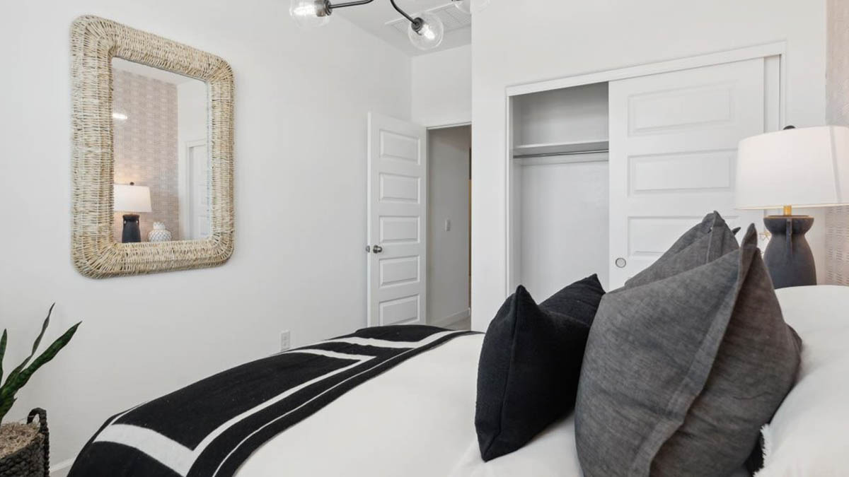 Comfortable guest bedroom featuring neutral-toned walls, carpeted flooring, and a large closet. With secondary bathroom in between bedrooms.