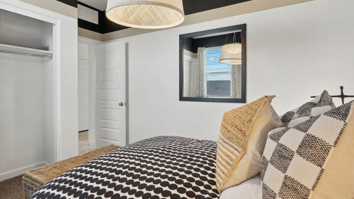 Comfortable guest bedroom featuring neutral-toned walls, carpeted flooring, and a large closet.