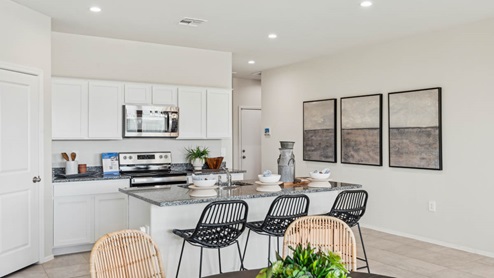 Bright and spacious kitchen with granite countertops, stainless steel appliances, and an island with bar seating.