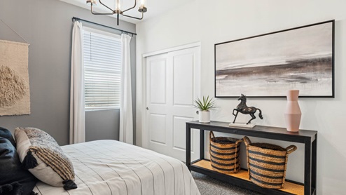 Comfortable guest bedroom featuring neutral-toned walls, carpeted flooring, and a large closet.