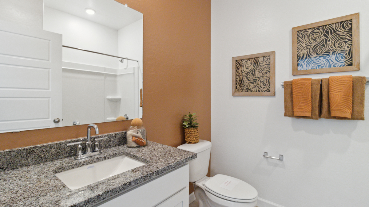 Family full bathroom with tub-shower combo, vanity, mirror, and polished fixtures Heartland Ranch