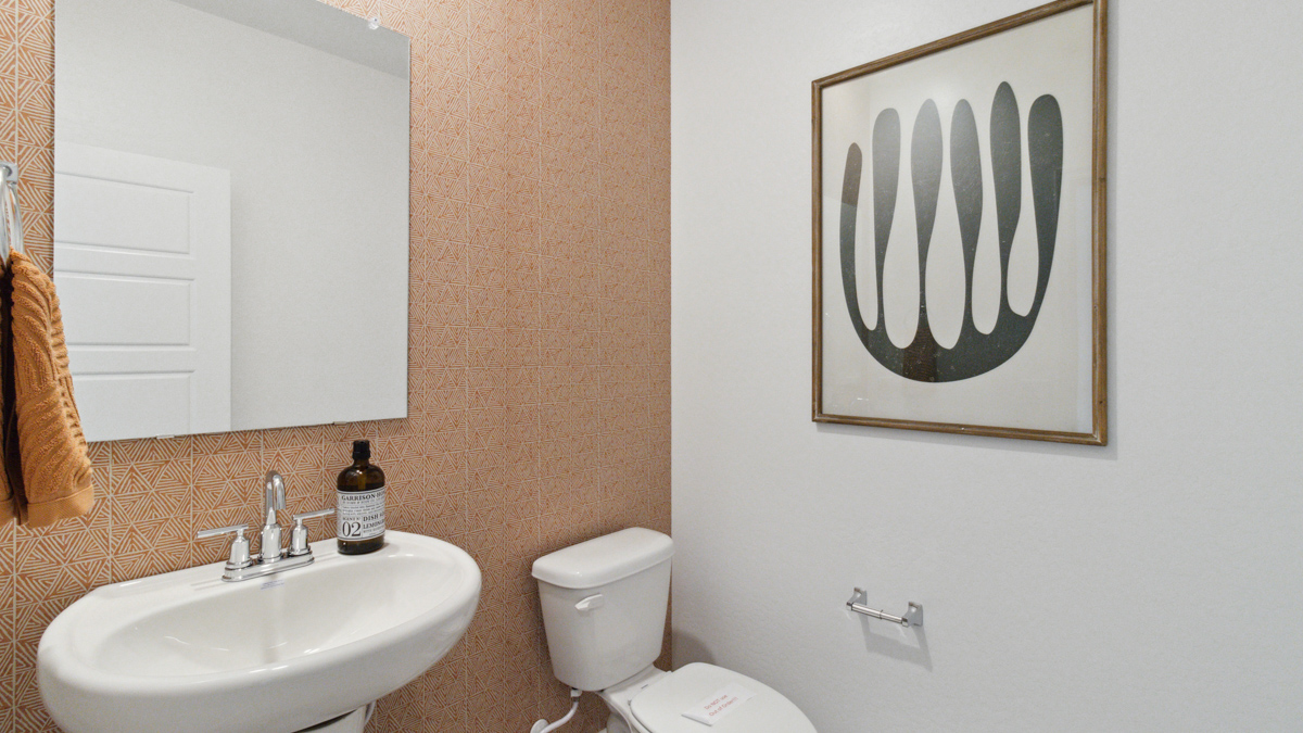 Half bath near living areas with pedestal sink and mirror Heartland Ranch