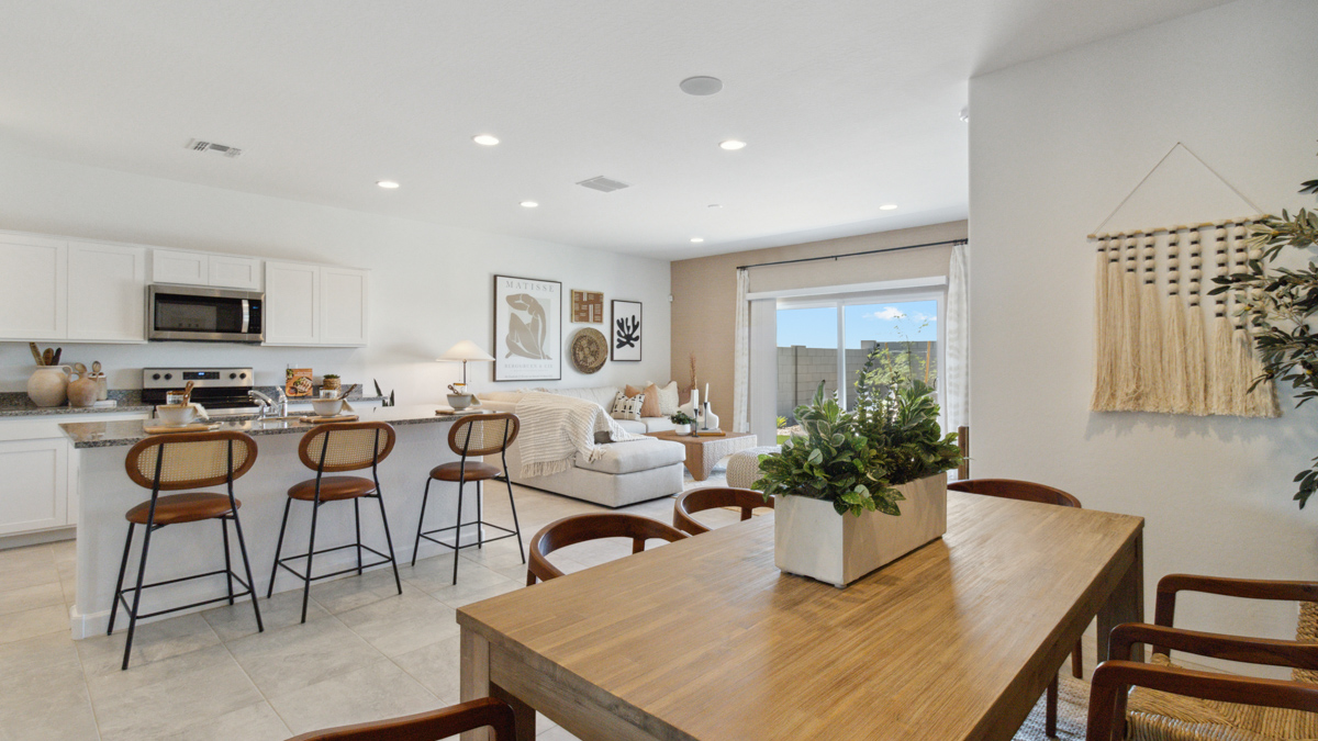 Dining area with view toward kitchen, appliance suite included, and backyard access