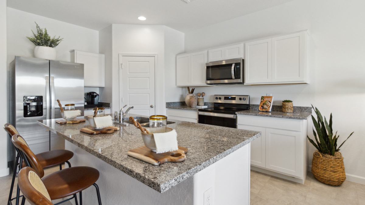 Kitchen island with sink, pantry access, cabinets, and full appliance suite included Heartland Ranch