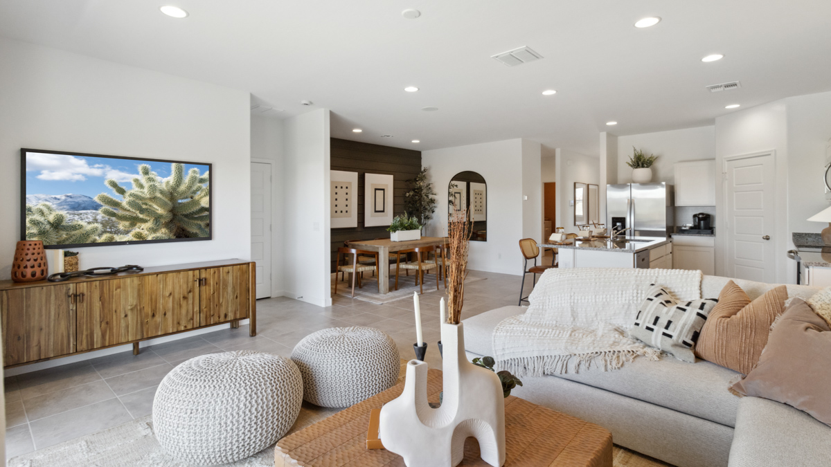 Living room with view into dining and kitchen areas showing open layout and appliance suite included