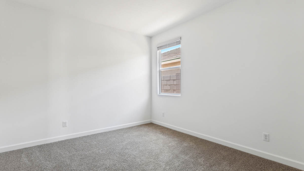 bedroom with beige carpet, white walls and a window