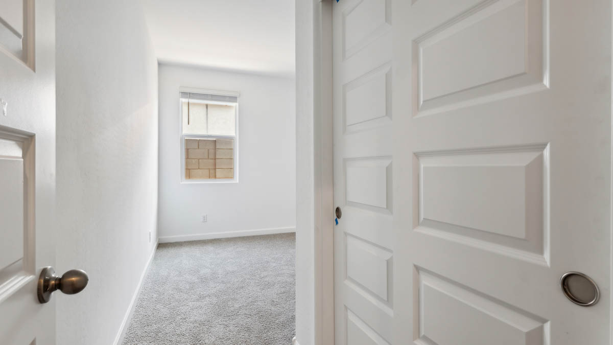 bedroom with beige carpet, white walls and a window