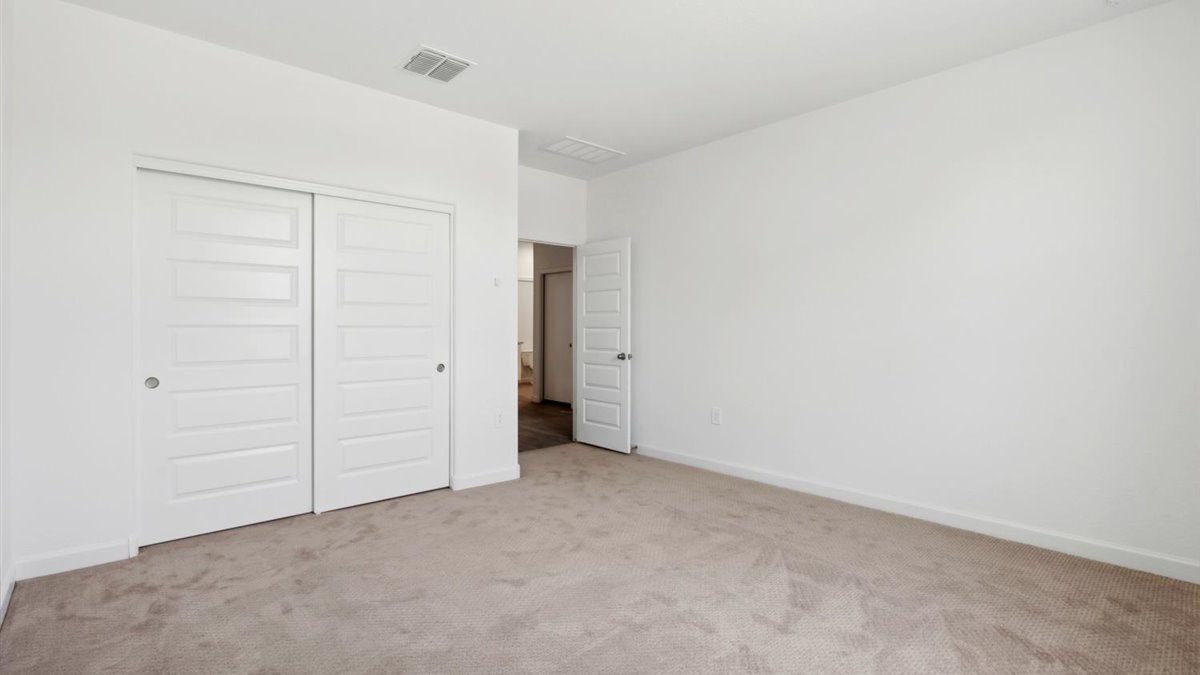 bedroom with beige carpet, white walls and a window