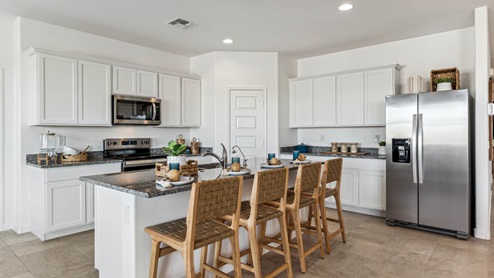 Bright and spacious kitchen with granitecountertops, stainless steel appliances, and an island with bar seating.