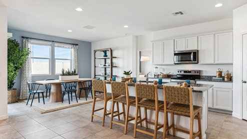 Contemporary kitchen adorned with white cabinets seamlessly integrated into an open dining area layout.