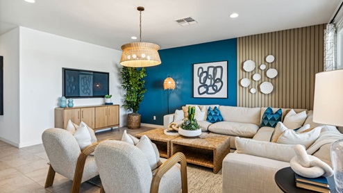 A cozy living room featuring a comfortable couch, a stylish coffee table, and an elegant painting on the wall.