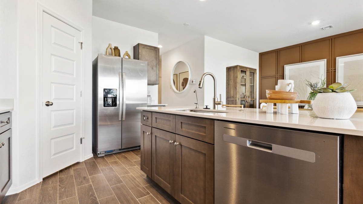 Bright and spacious kitchen with countertops, stainless steel appliances, and an island with bar seating.