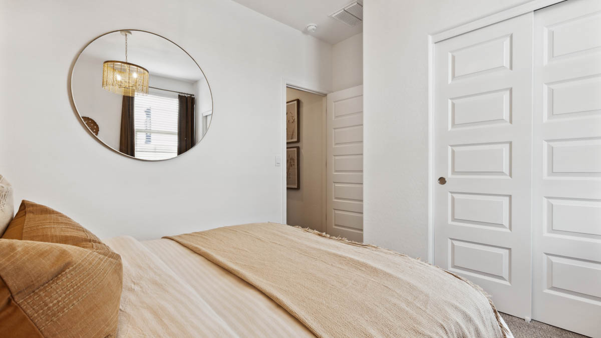 Comfortable guest bedroom featuring neutral-toned walls, carpeted flooring, and a large closet.
