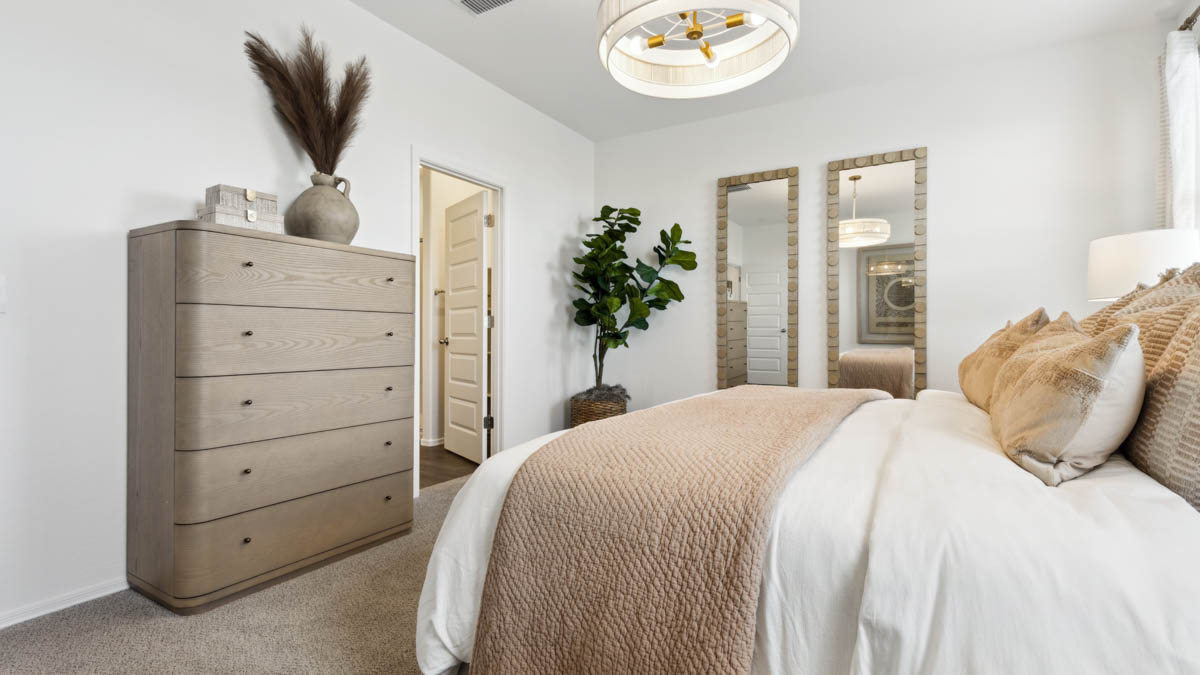 Modern primary bathroom with double vanities, with a walk-in shower and a walk-in closet.