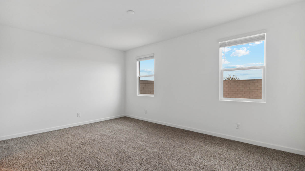 A spacious primary bedroom emphasizing open space and natural lighting.