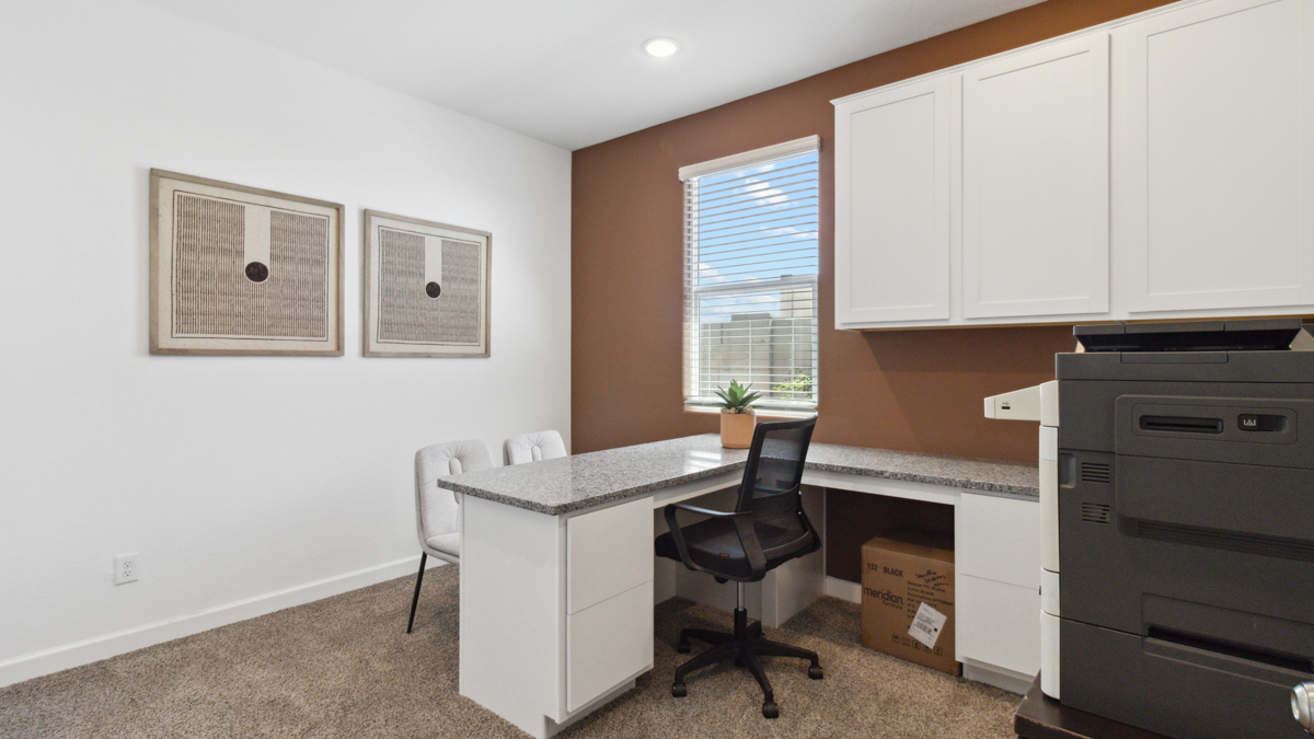 A tidy office featuring a desk, chair, and a window, creating a bright and organized workspace.