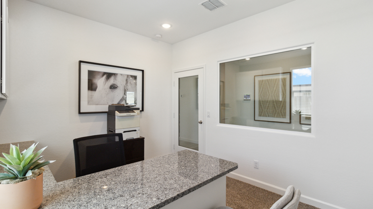 A tidy office featuring a desk, chair, and a window, creating a bright and organized workspace.